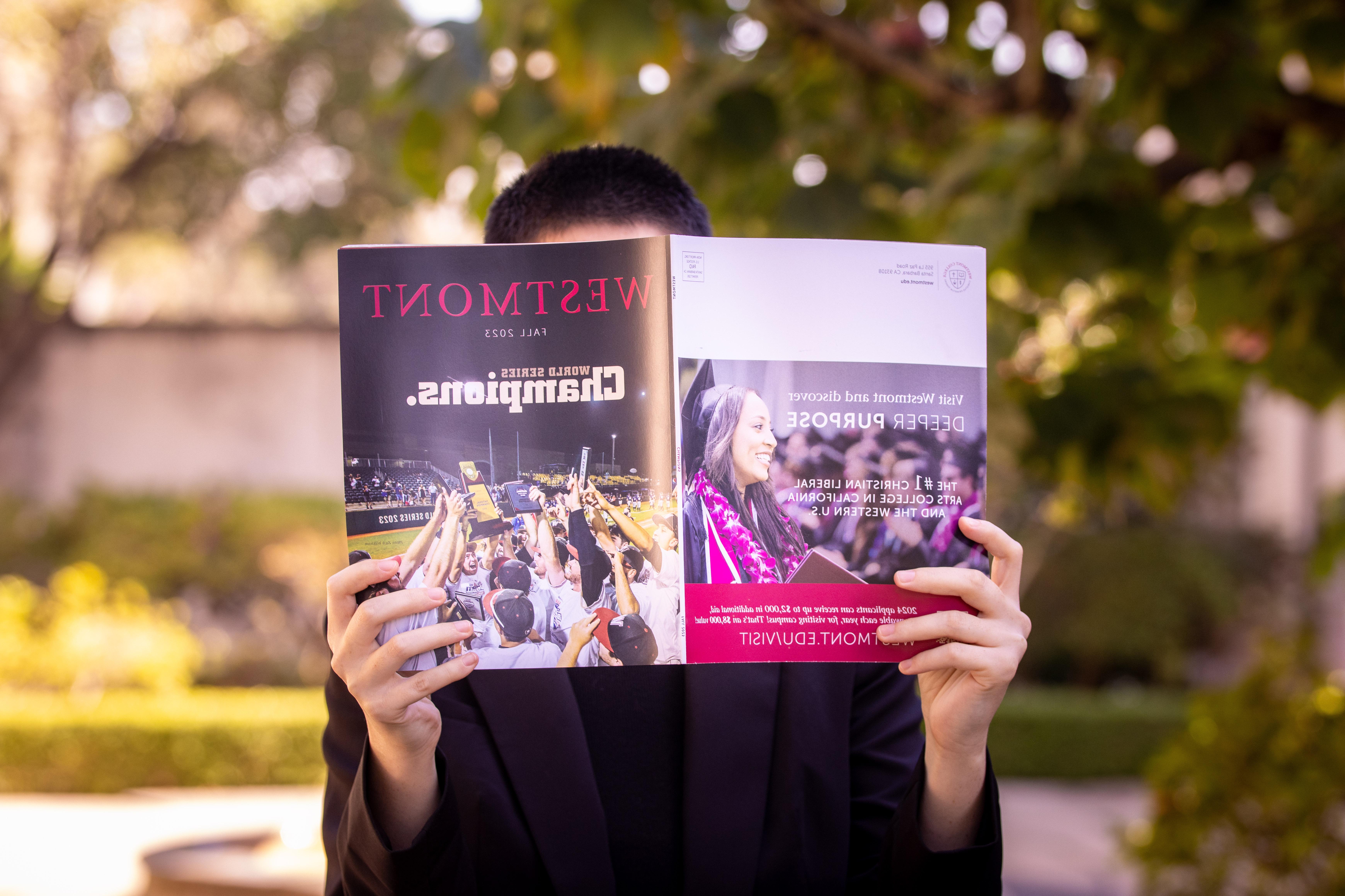 person holding up westmont magazine